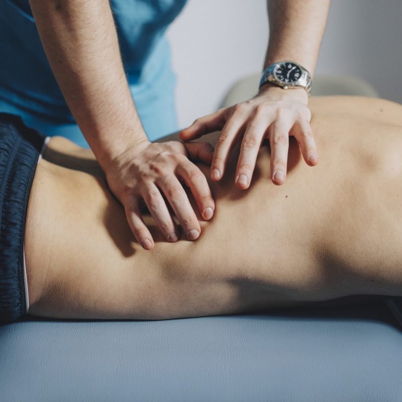 Hands-on joint mobilisation being applied to the mid and lower back